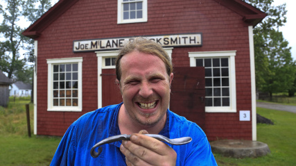 Male costumed interpreter holding a spoon