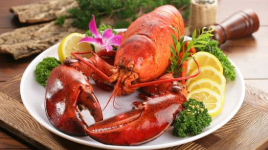 Cooked lobster on a plate with lemon.